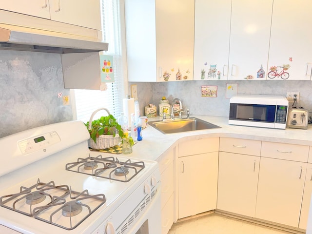 kitchen featuring a sink, white appliances, under cabinet range hood, and light countertops