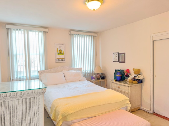 bedroom with multiple windows and light colored carpet