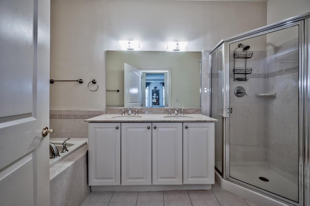 full bath featuring a sink, a garden tub, a shower stall, and tile patterned floors