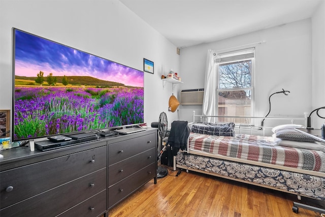 bedroom featuring light wood-type flooring and cooling unit