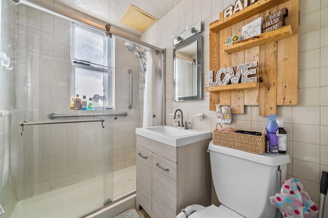 bathroom with tasteful backsplash, toilet, a stall shower, and tile walls