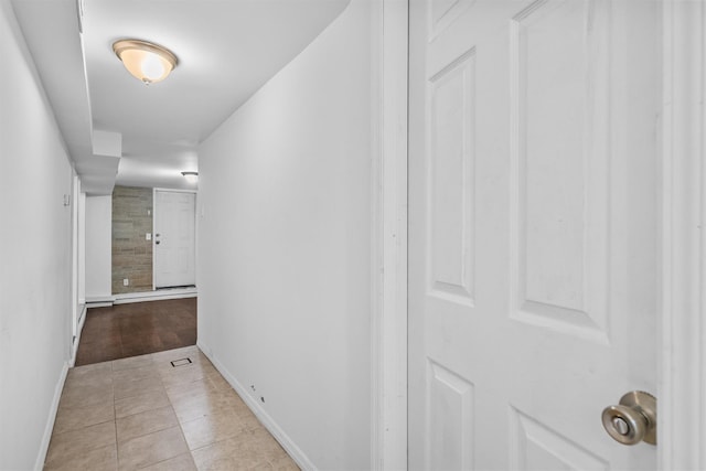 corridor featuring tile patterned flooring and baseboards