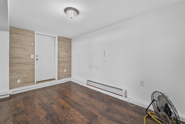 empty room with wood finished floors and a baseboard radiator