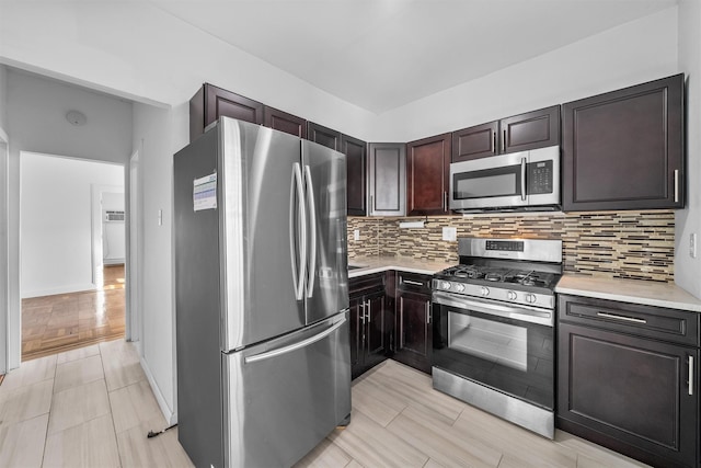 kitchen with tasteful backsplash, appliances with stainless steel finishes, and light countertops