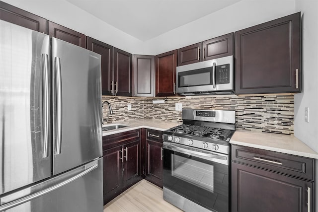 kitchen featuring light countertops, tasteful backsplash, appliances with stainless steel finishes, and a sink