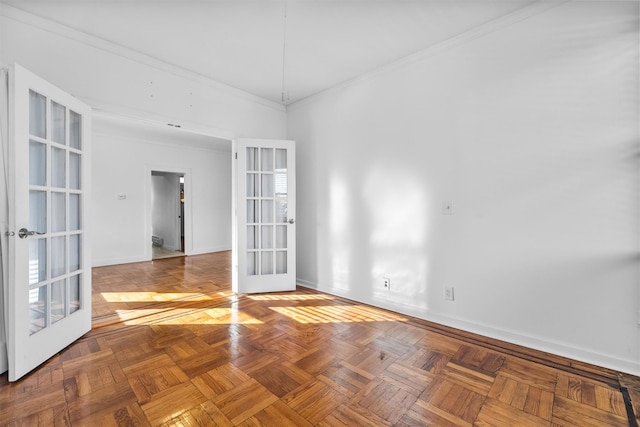 empty room with french doors, baseboards, and crown molding