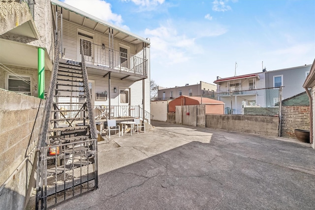 view of patio featuring stairway and fence