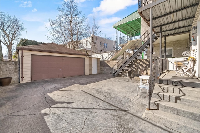 exterior space with an outbuilding, stairway, and a garage