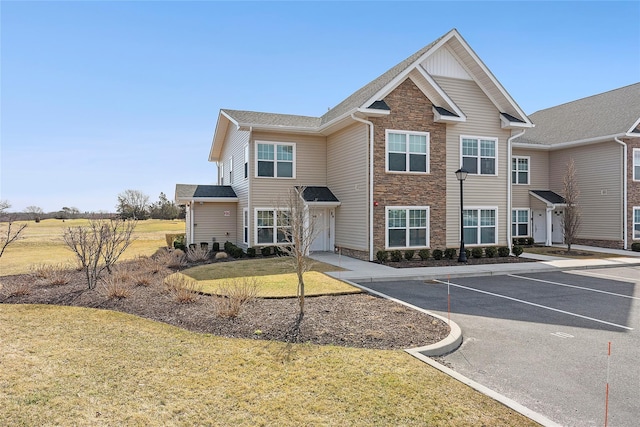 view of front of home featuring a front yard and uncovered parking