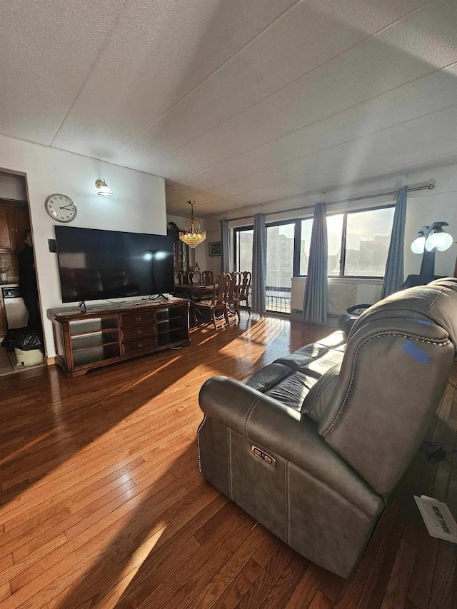 living area with a notable chandelier, a textured ceiling, and wood-type flooring