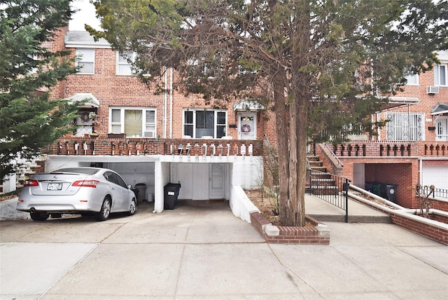 view of property featuring brick siding and concrete driveway