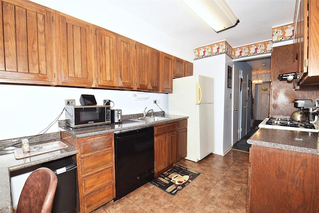 kitchen featuring a sink, stainless steel microwave, black dishwasher, dark countertops, and freestanding refrigerator