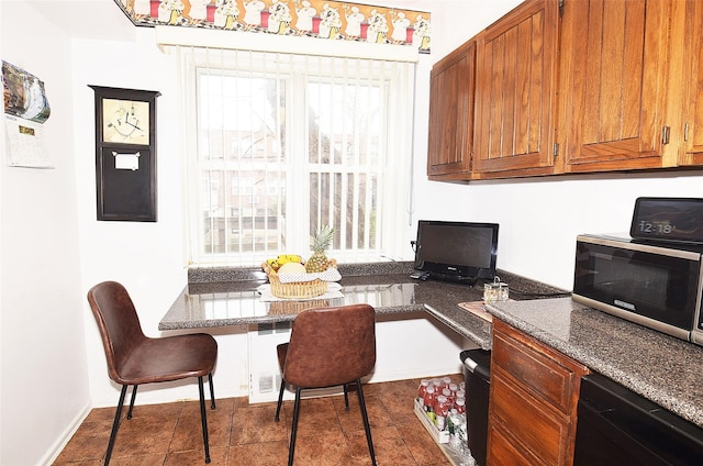 dining room featuring breakfast area, dark tile patterned flooring, a healthy amount of sunlight, and radiator heating unit