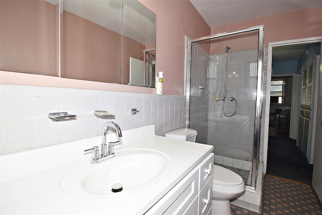 full bath featuring vanity, tile walls, toilet, and a stall shower