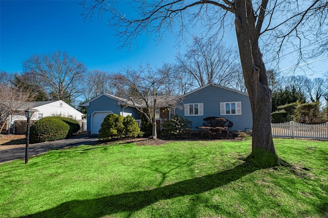 view of front of home with a garage, driveway, a front yard, and fence