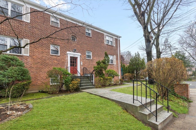 view of front of house with a front lawn and brick siding