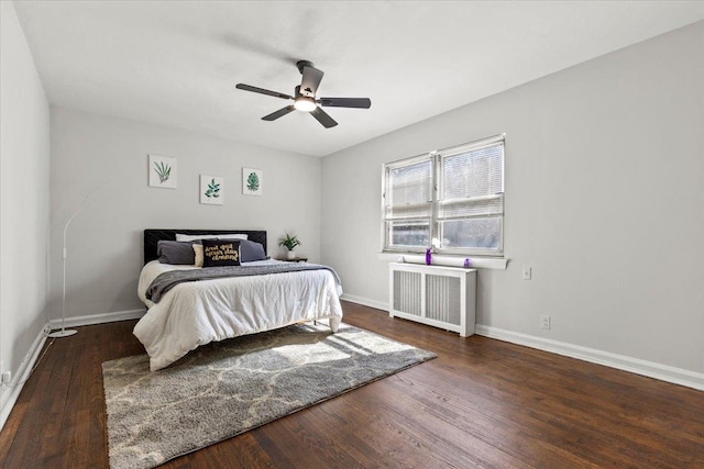 bedroom featuring ceiling fan, baseboards, wood finished floors, and radiator heating unit