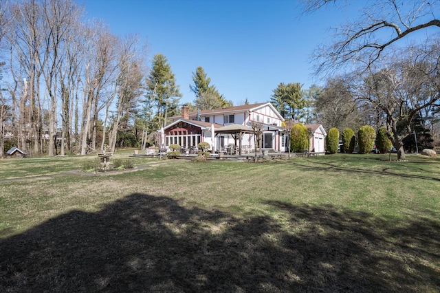 back of house with a gazebo, a lawn, and a chimney