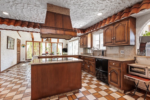 kitchen with black appliances, light stone countertops, light floors, and a sink