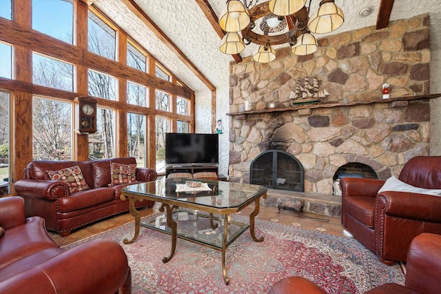 living room with a wealth of natural light, beamed ceiling, and a stone fireplace