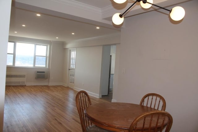 dining room with radiator, wood finished floors, recessed lighting, and ornamental molding