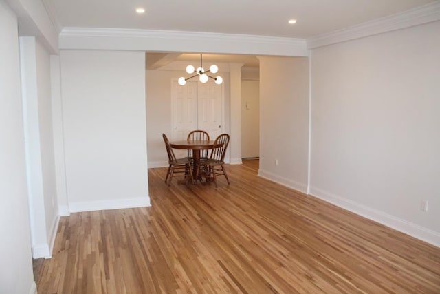 dining space featuring baseboards, light wood-style floors, and ornamental molding