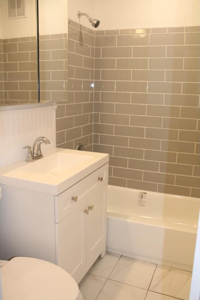 full bath with vanity, visible vents, shower / bath combination, tile walls, and toilet