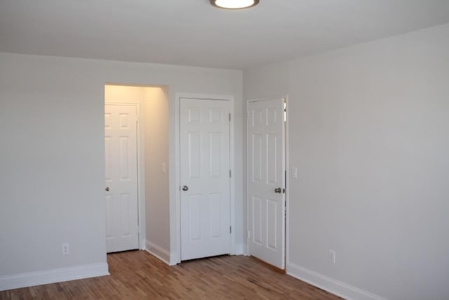 unfurnished bedroom featuring wood finished floors and baseboards