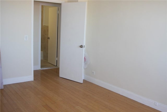 empty room with baseboards and light wood finished floors