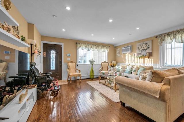 living room featuring dark wood finished floors, recessed lighting, a healthy amount of sunlight, and a wall mounted AC