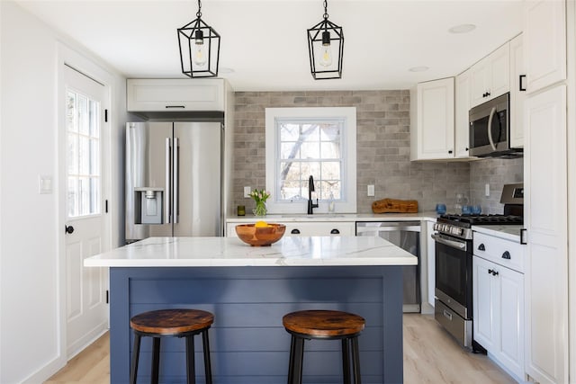 kitchen with a breakfast bar area, a kitchen island, a sink, decorative backsplash, and stainless steel appliances