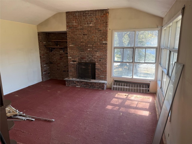 unfurnished living room featuring carpet floors, radiator, a brick fireplace, and vaulted ceiling