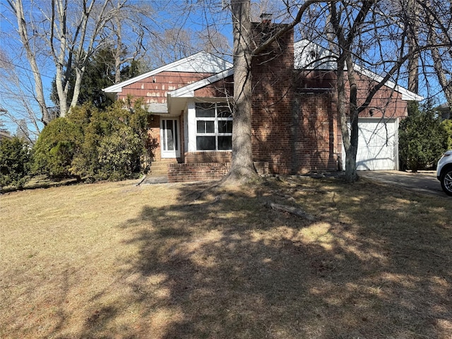 view of front of home featuring a garage, brick siding, and a front lawn