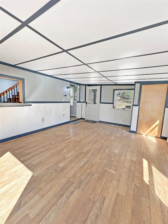 unfurnished room with wood finished floors and a wainscoted wall