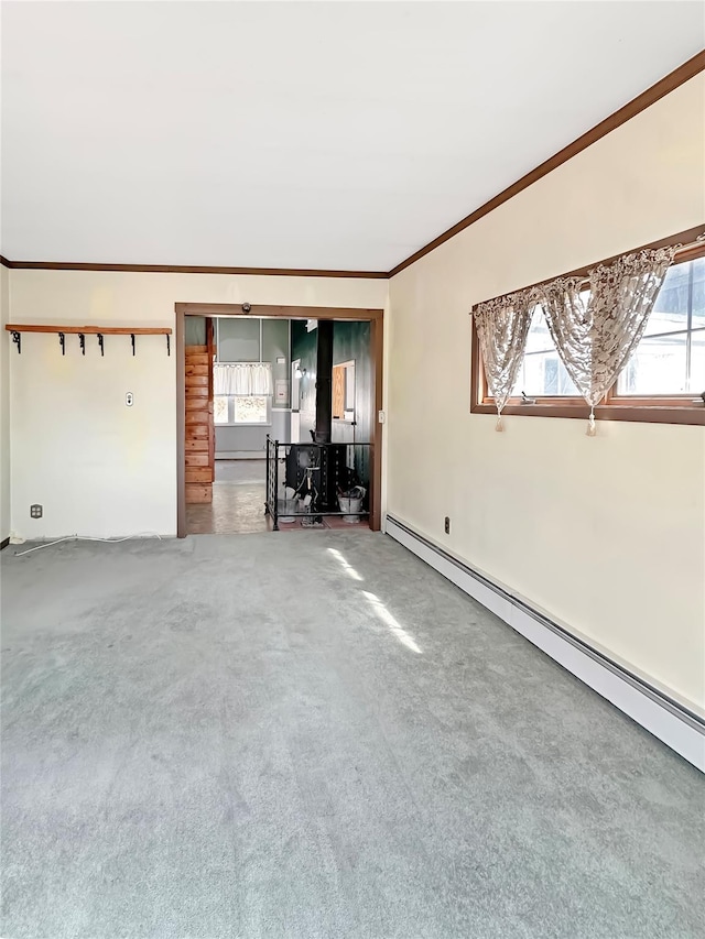 unfurnished living room with a baseboard heating unit, carpet floors, and ornamental molding