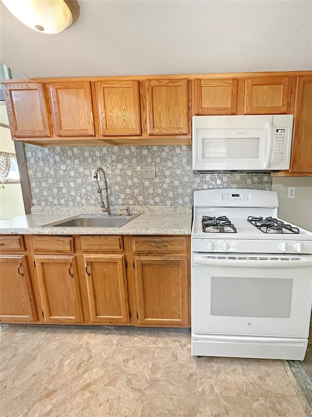 kitchen with tasteful backsplash, light countertops, brown cabinets, white appliances, and a sink