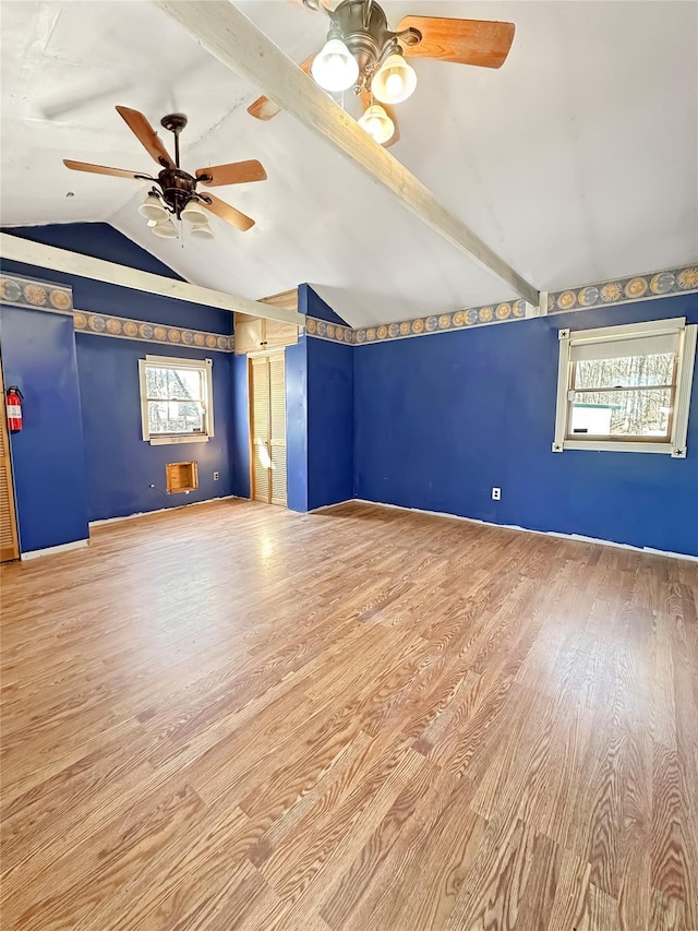 unfurnished room with lofted ceiling with beams, wood finished floors, and ceiling fan