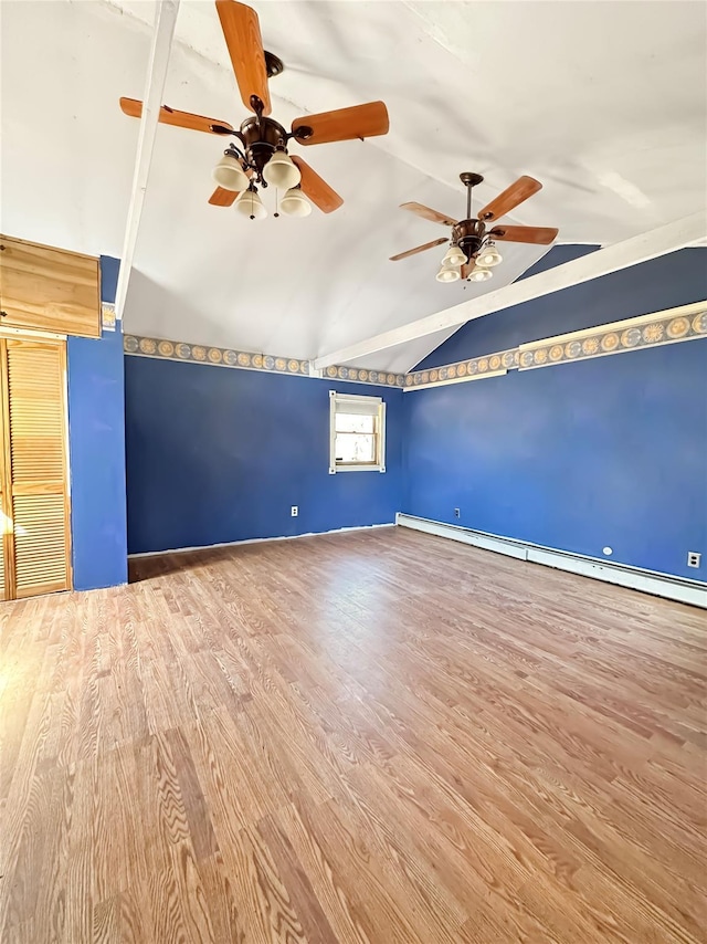 spare room with a ceiling fan, vaulted ceiling, wood finished floors, and a baseboard radiator