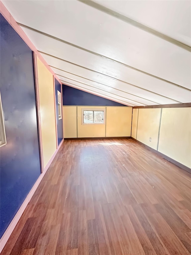 empty room featuring lofted ceiling and wood finished floors