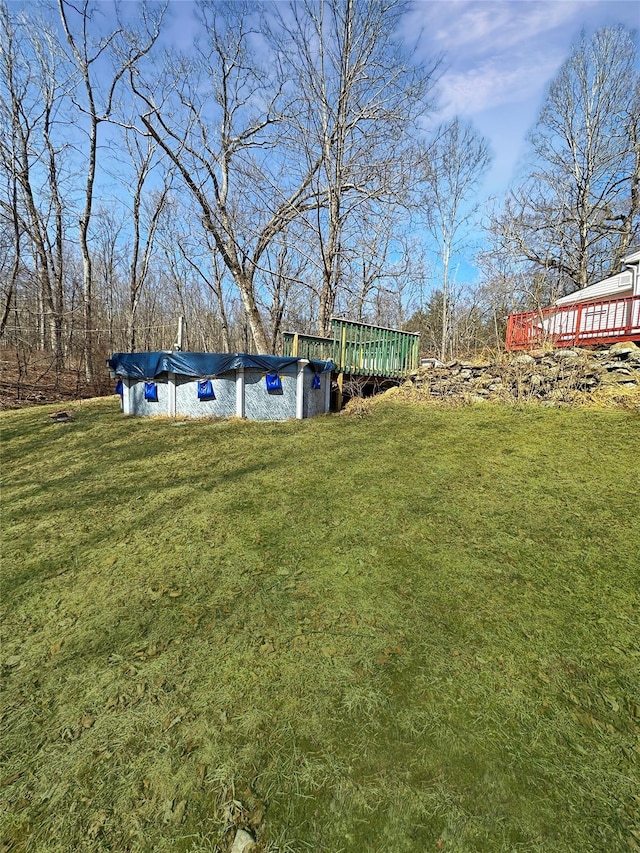 view of yard featuring a covered pool and a deck