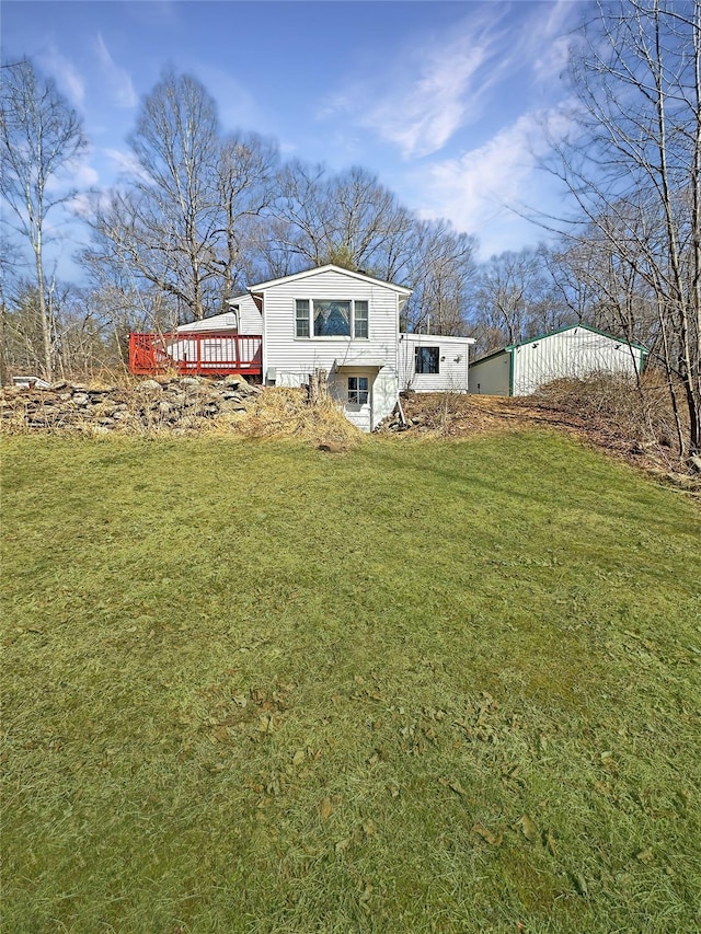 rear view of property with a lawn and a wooden deck