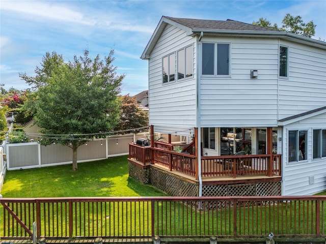 back of house with a lawn, a wooden deck, a fenced backyard, and roof with shingles