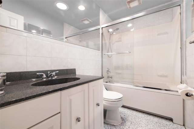 full bath featuring vanity, recessed lighting, bath / shower combo with glass door, tile walls, and toilet