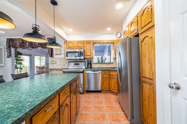 kitchen with light tile patterned floors, decorative backsplash, dark countertops, and appliances with stainless steel finishes