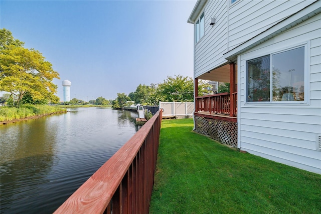 view of yard with fence and a deck with water view