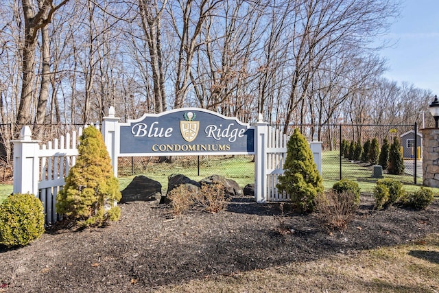 community / neighborhood sign featuring a gate and fence