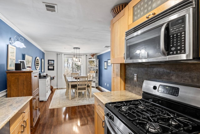 kitchen featuring visible vents, backsplash, ornamental molding, appliances with stainless steel finishes, and dark wood-style floors