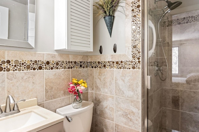 bathroom with vanity, a shower stall, toilet, and tile walls