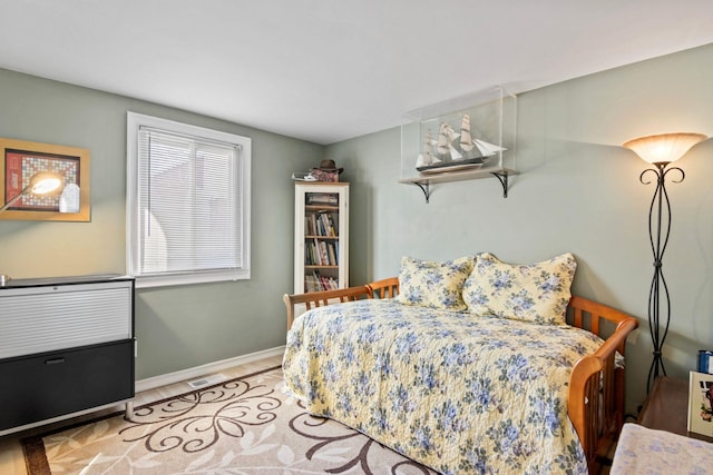 bedroom with visible vents, baseboards, and wood finished floors