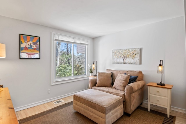 sitting room featuring visible vents, baseboards, and wood finished floors